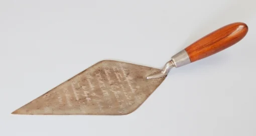 Tarnished silver trowel with polished wooden handle. 