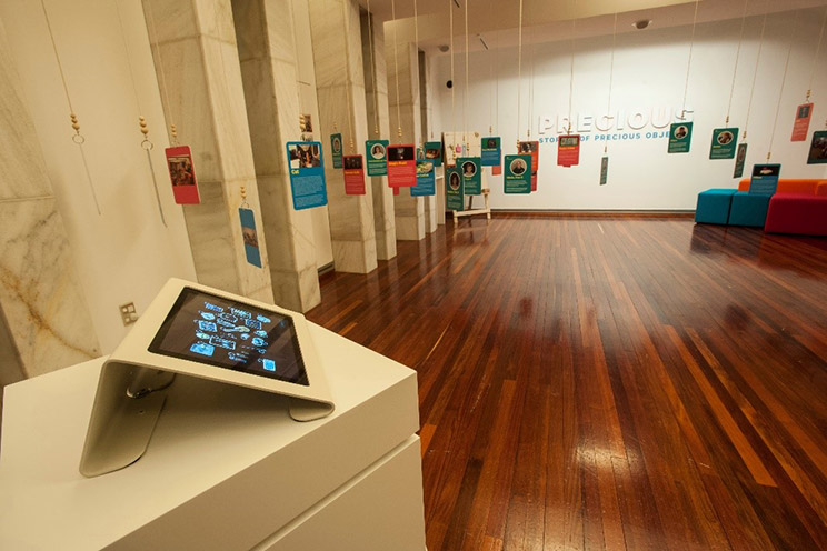 Exhibition of pictures hanging from a ceiling.