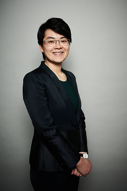 Smiling Hong Kong-Chinese woman wearing a dark business suit. 