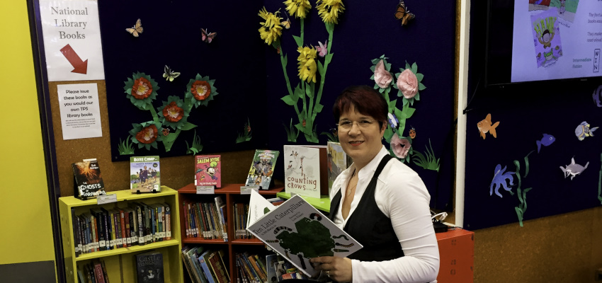 Sandi Faulconbridge in front of the school’s National Library display" alt="Sandi Faulconbridge in front of the school’s National Library display