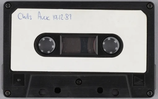 An audiocassette with white label and in upper left corner some writing in blue ballpoint pen. 