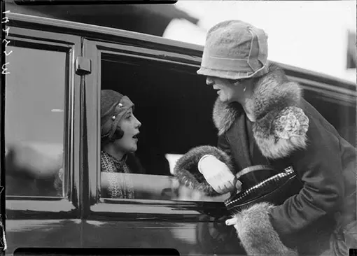 Two women talking through car window.