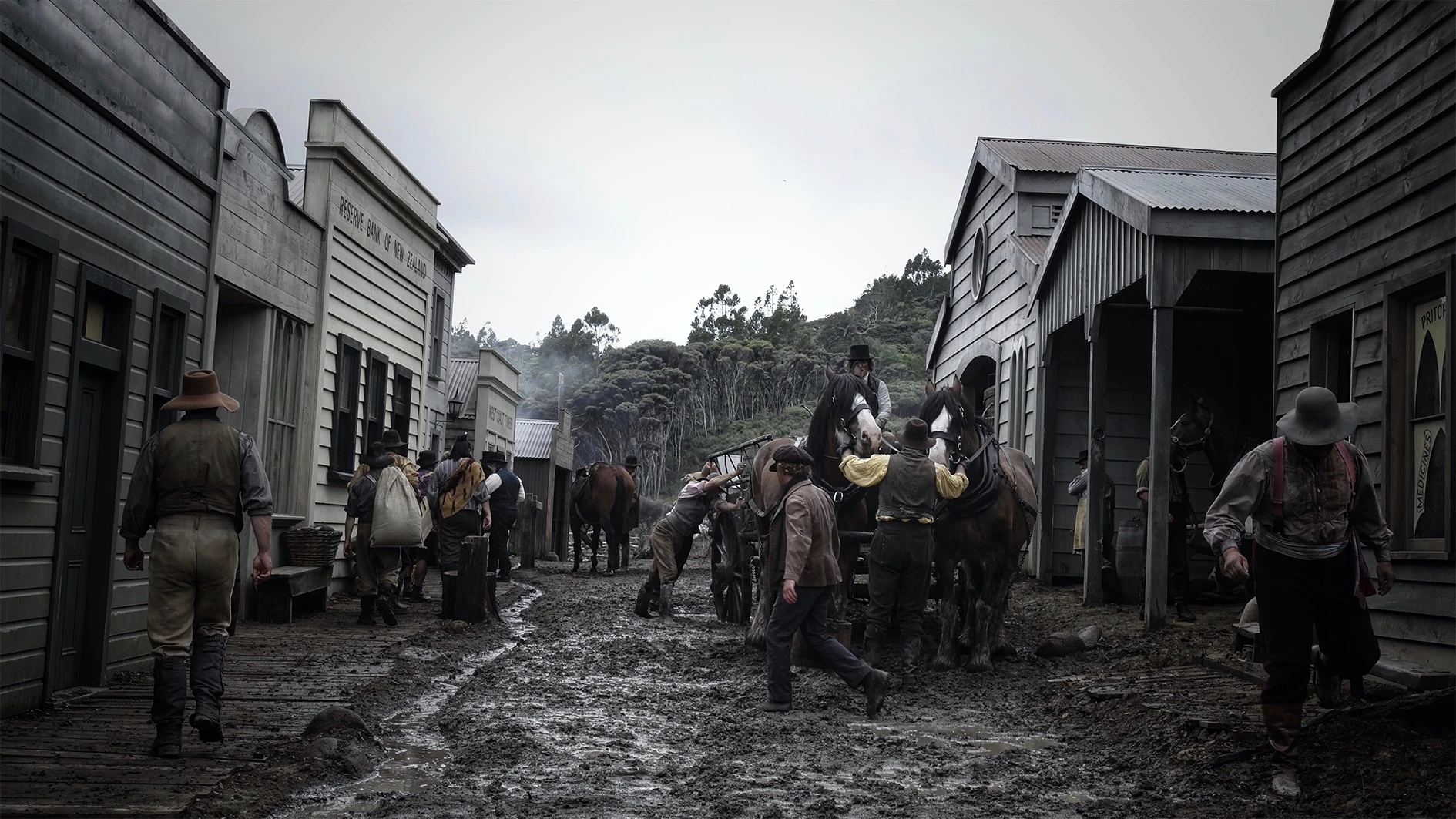 A bustling street scene with various men loading a wagon and walking about along the street.