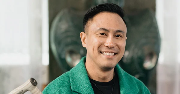 Head and shoulders image of Chris Tse, smiling and wearing a green jacket.