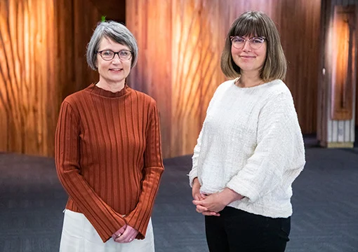 Two women smiling at the camera.