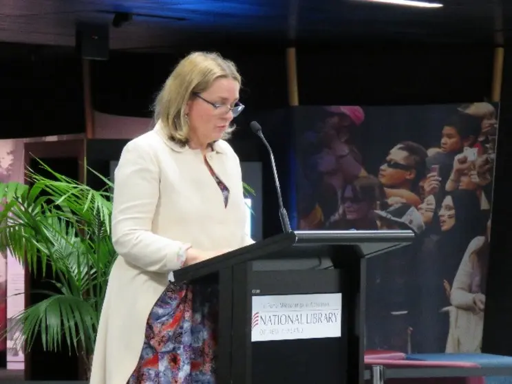 Woman standing at a podium.