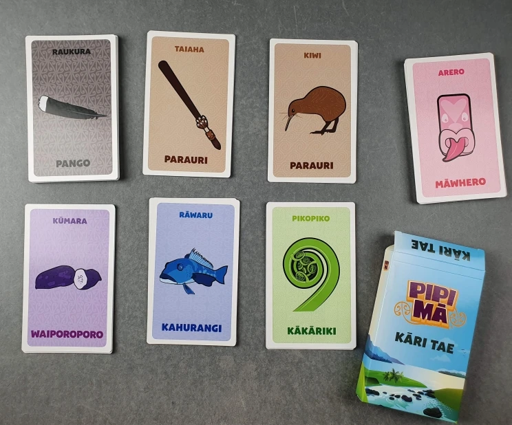 An arrangement of colourful playing cards depicting various Māori words and their corresponding images.