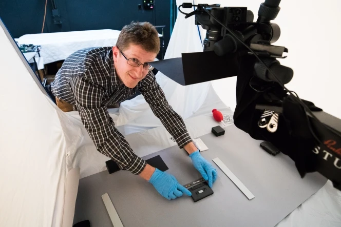 Llewe Jones, Imaging Technician/Photographer, photographing Flying Nun cassettes in a studio environment.