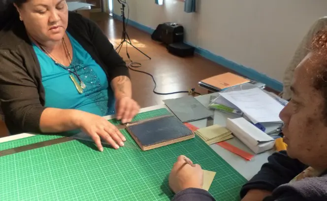 Mary Bercich and Evelyn Barber measuring their book before making their four-flap folder.