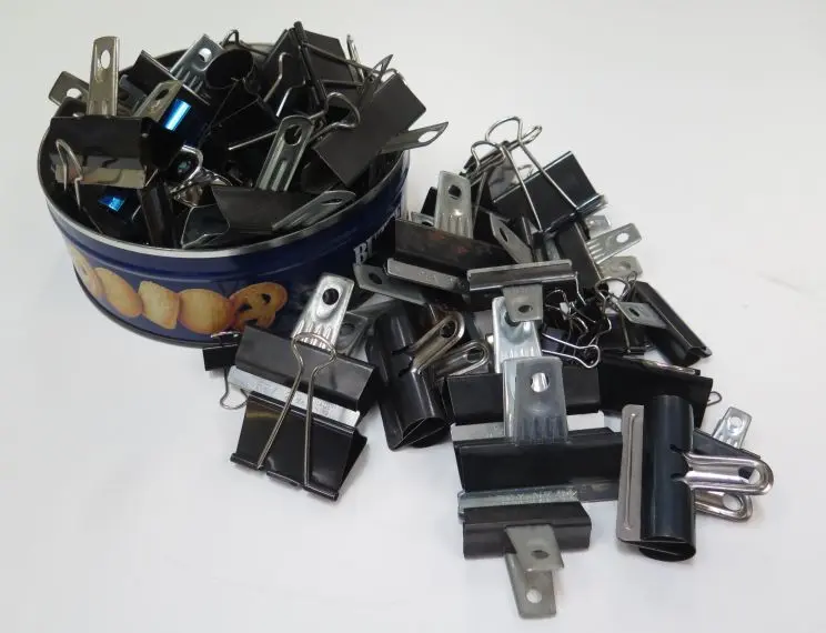 A pile of metal binder clips of various sizes and shapes. 