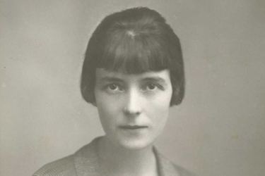 Sepia photo of woman with a bob haircut looking intensely at the camera.