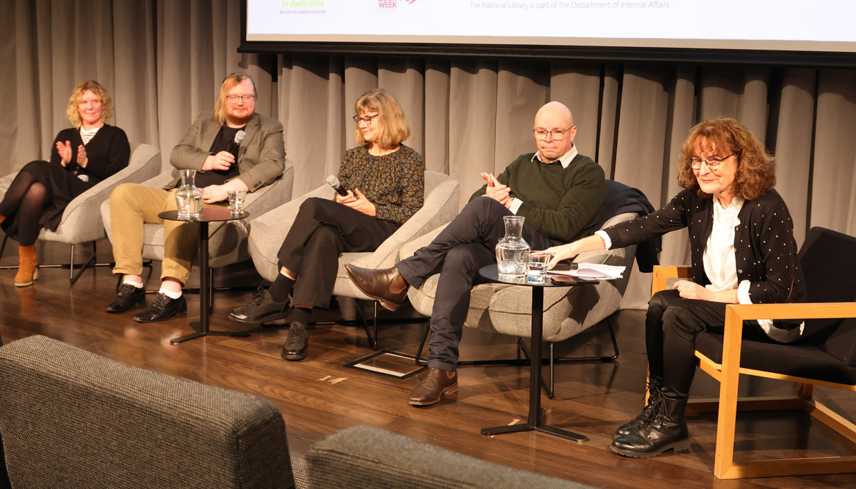 Kate De Goldi, seated with 4 other panellists, takes questions at a National Library panel event.