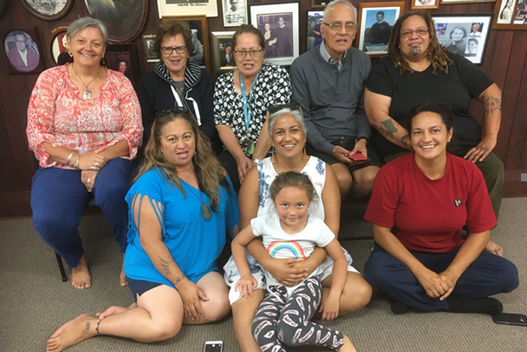 Field Conservator, Vicki-Anne Heikell (left) with Kiekie marae whanau on an NPO visit just prior to lockdown with the group seated on chairs and on the floor.