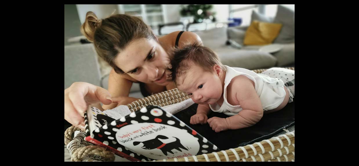 A parent and baby reading a book together.