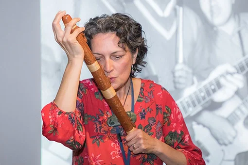 Woman playing a traditional Māori instrument. 