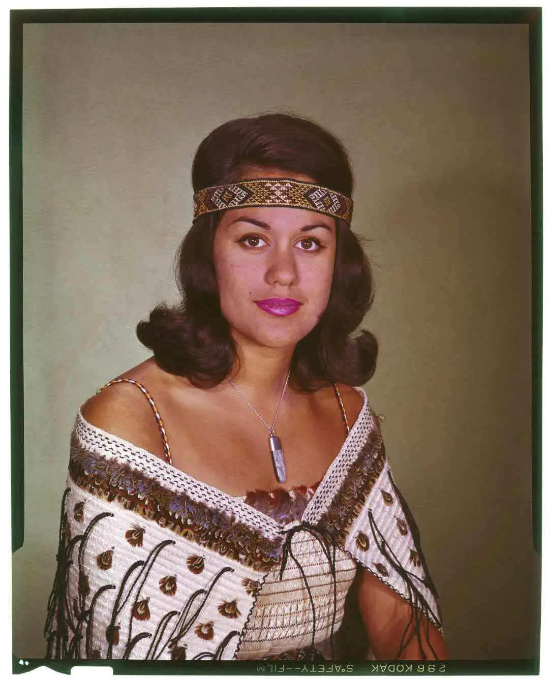 Portrait of a woman with a Māori cloak and headband. 
