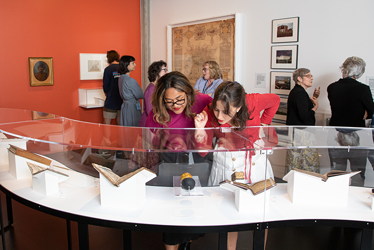 Two young women looking at a display case at the Mīharo Wonder exhibition. 