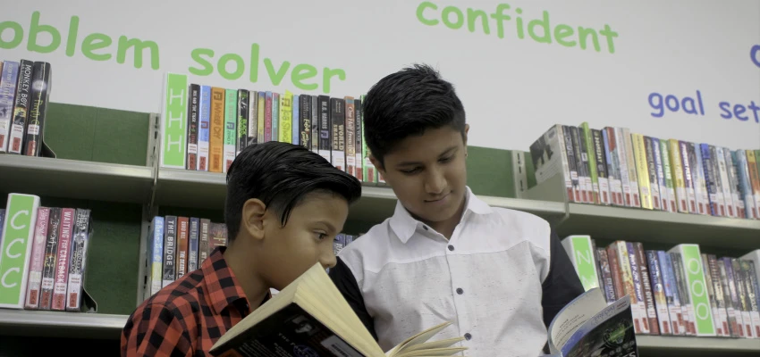 Two boys reading in their school library.