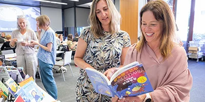 Teachers looking at books on display at a workshop.