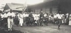 A large group of people appear to be gathered and walking together along a road.