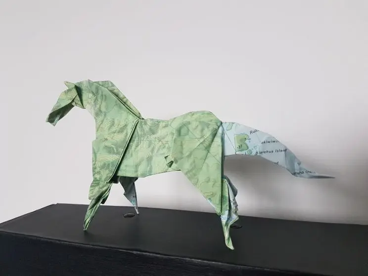 A picture of a horse shape made from a folded map, including two ears, a mane and long tail. 