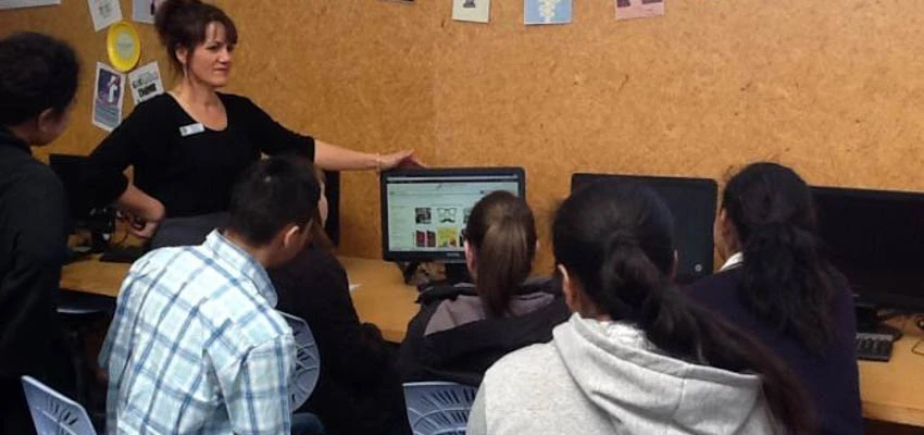 Freyberg High School students and staff gathered around a computer