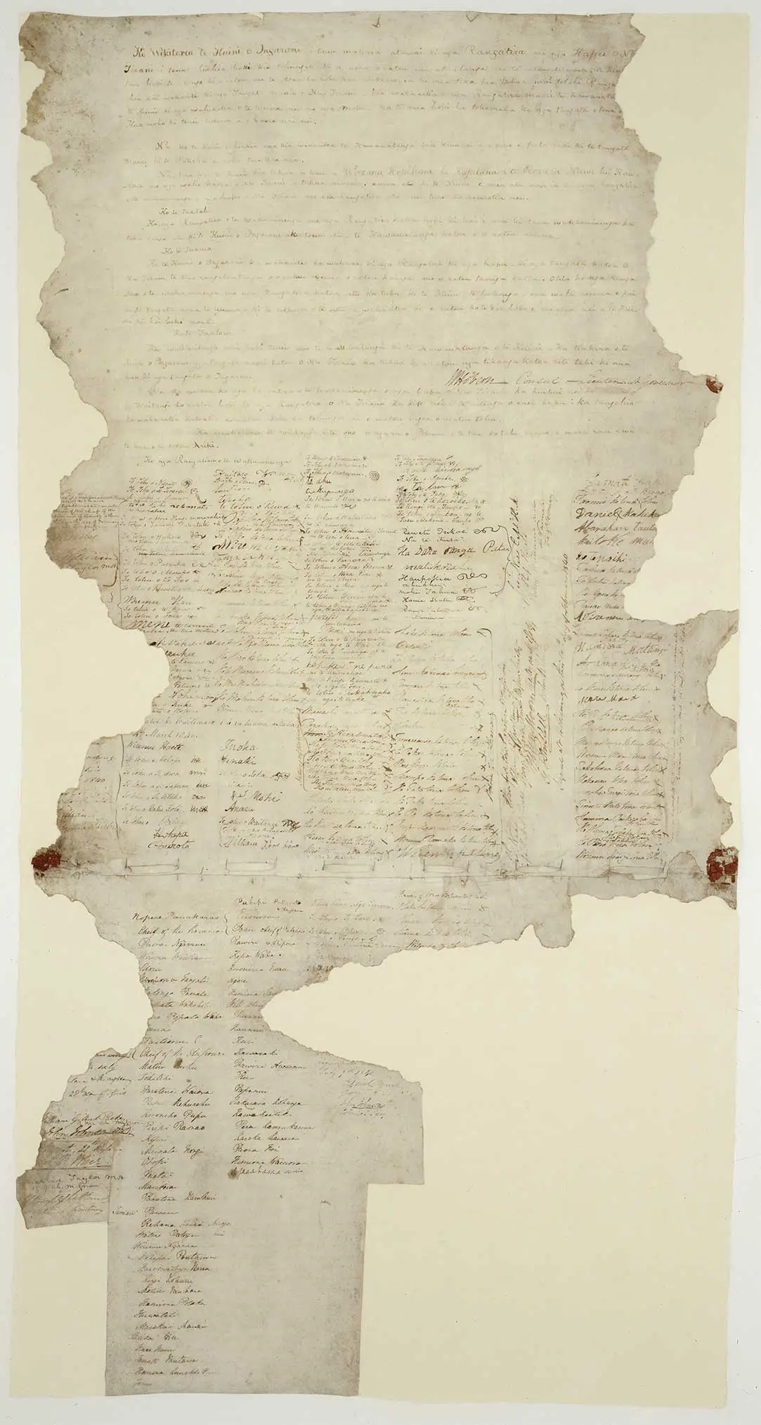 The Waitangi sheet of te Tiriti o Waitangi — the Treaty of Waitangi. It shows handwriting in te reo Māori at the top with signatures or marks from rangatira below. The sheet is badly degraded and much of the outer edges are missing, particularly at the bottom of the sheet.