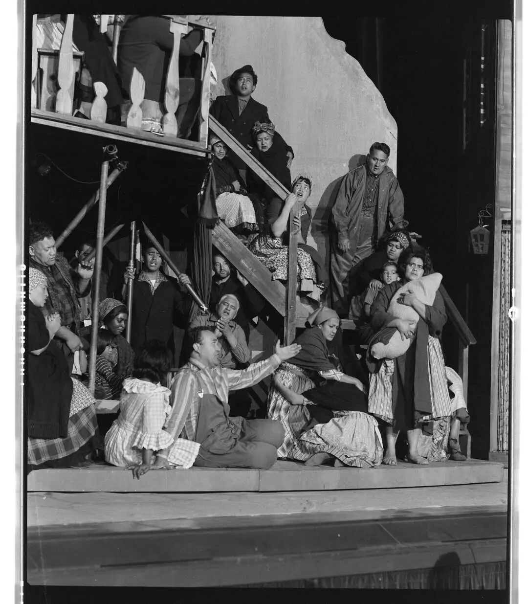 Group of scared looking people sitting on and at the bottom of a staircase. 