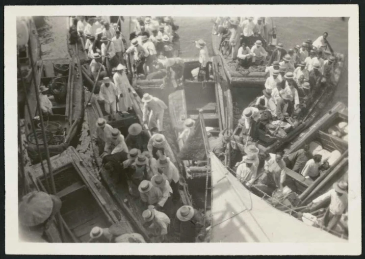 View looking down into crowded boats with people seemingly changing between boats.