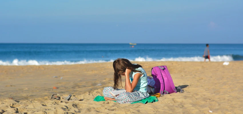 Girl reading a book on the beach