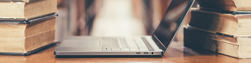 Detail of a photo of an open laptop and books. 