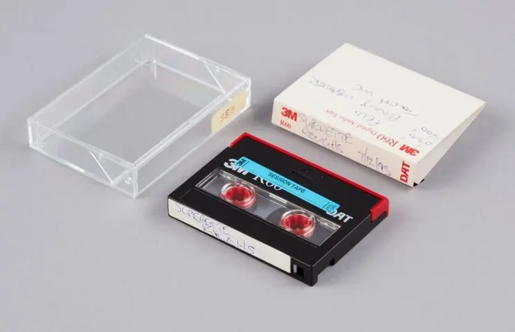 A preservation image showing DAT, plastic cover and paper insert with handwritten contents listing about the tape. 