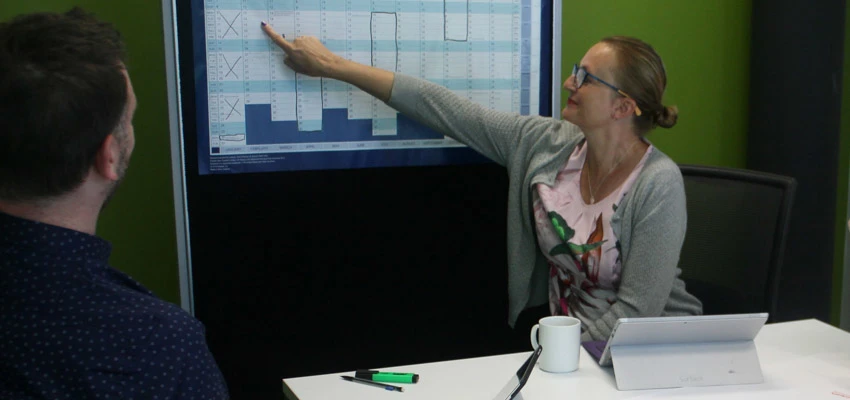 School librarian pointing at a planning chart.