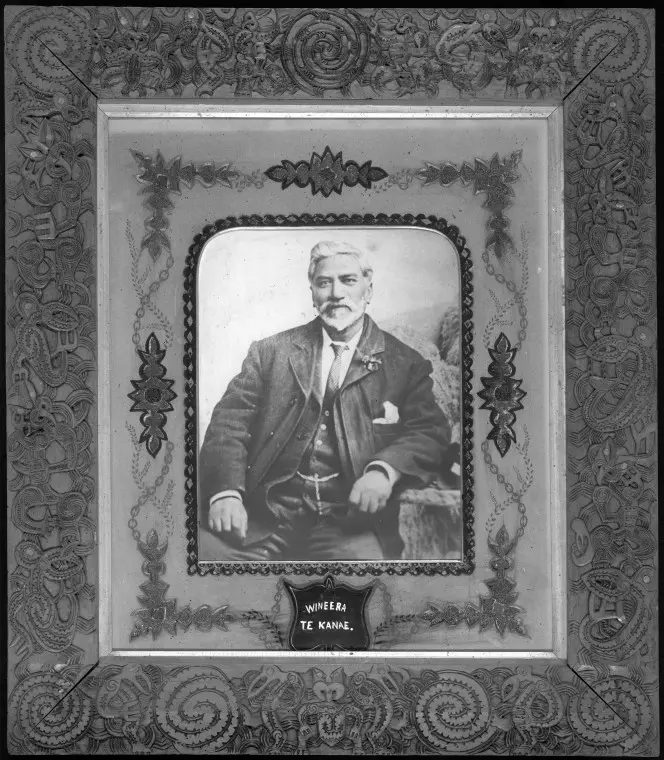 Portrait of Wineera Te Kanae, seated wearing a european suit. He appears to be about 50 years of age. The portrait is surrounded with a decorated mat board and well carved picture frame. The frame was carved by Piwiki Horohau, of Ngati Raukawa and Ngati Toa descent, about the time he carved the meeting house Toa Rangatira (ca 1900).