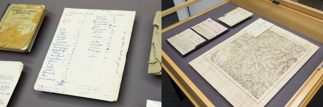 Collection items in a display case, including a map and papers.