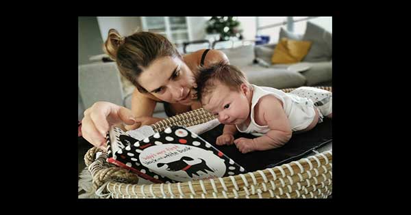 A parent and baby reading a book together.