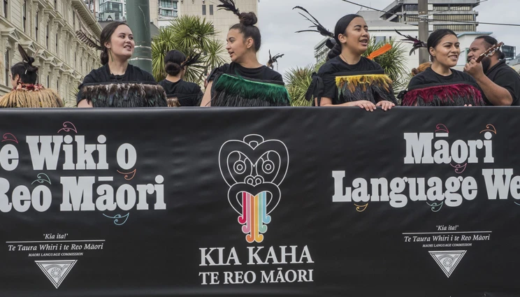 Young people marching with banner in Te Wiki o te Reo Māori parade