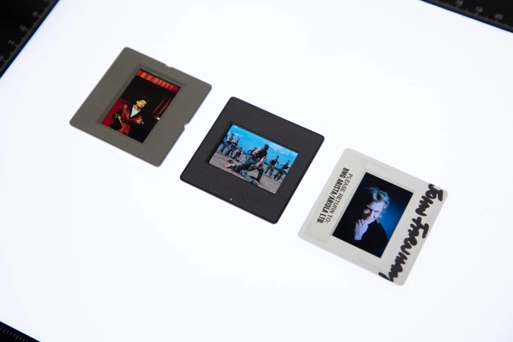Three different colour slides displayed in a row on a light table.