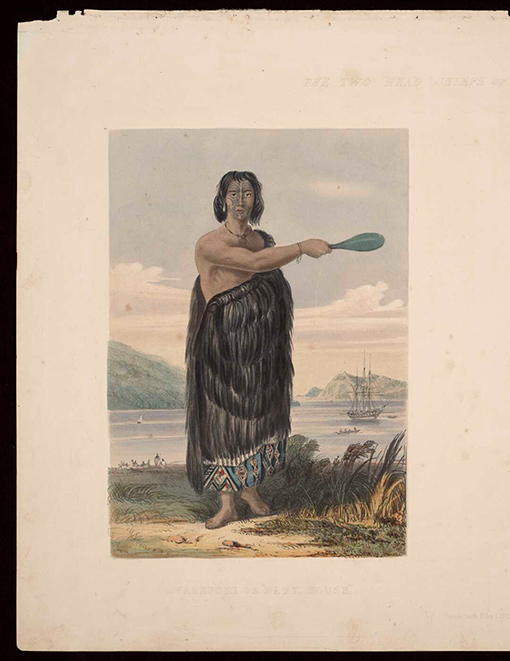 Māori man wearing a cloak and pointing with a mere.
