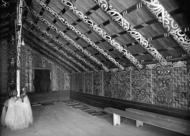 Interior view of Hinenuitepo meeting house at Te Whaiti. There are streamers across the ceiling, and photographs all along the walls.