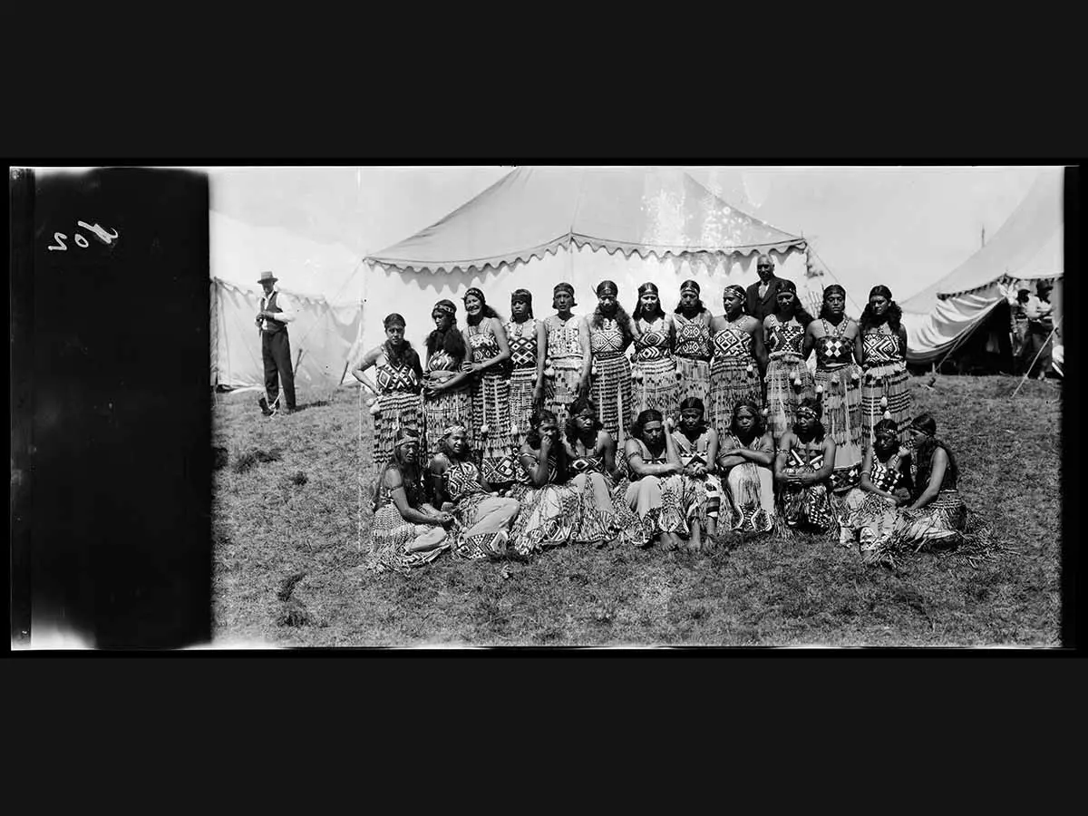 Black and white photo of a group of Māori — some wearing a piupiu (flax skirt), pari (bodice) and tīpare (headband) — at the first Waitangi Day commemoration.