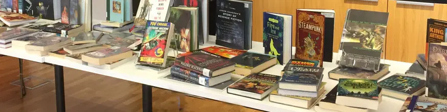 A table with a selection of fantasy books for people to read.