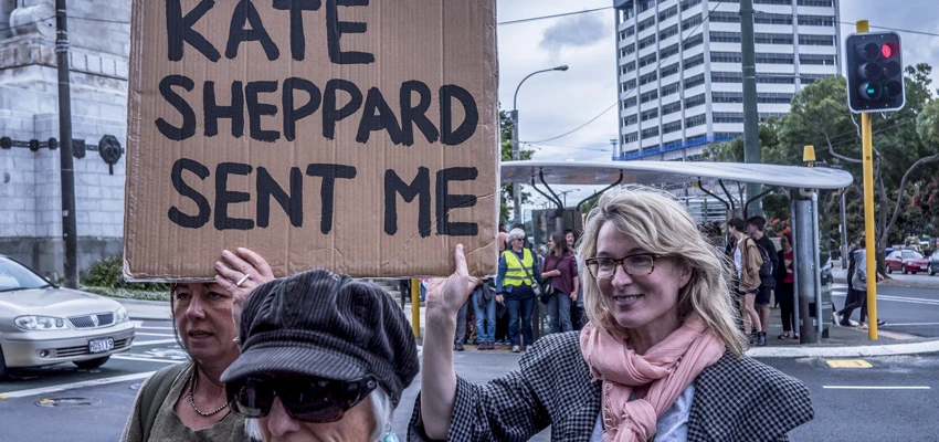 Women in 2017 Women's March in Wellington holding a sign saying 'Kate Sheppard sent me'