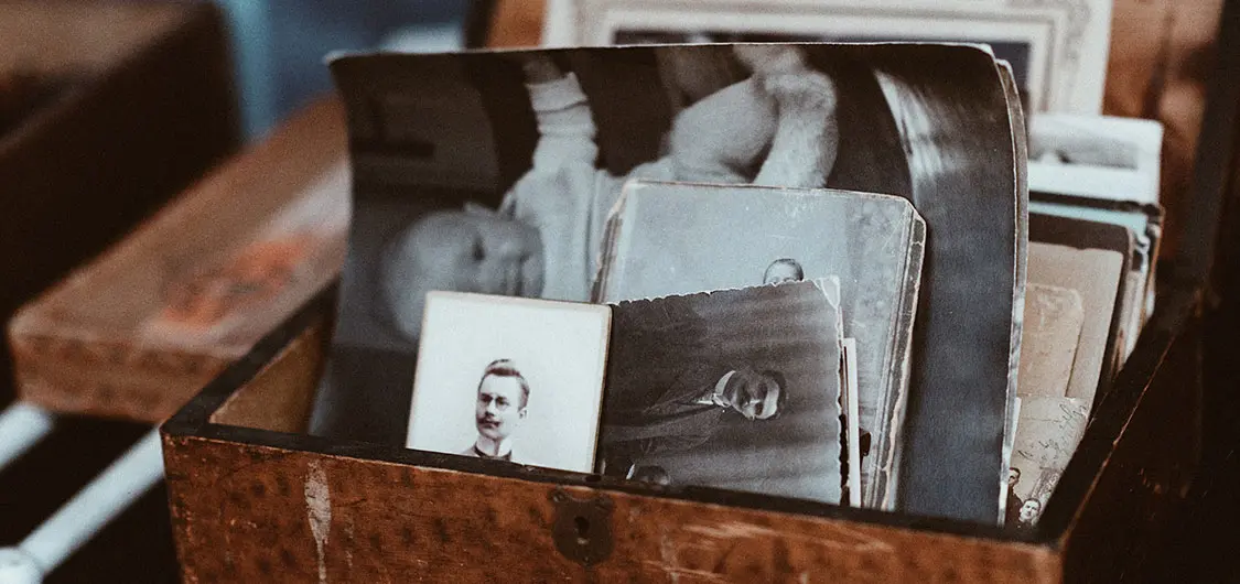 Old photos inside an open, wooden box.