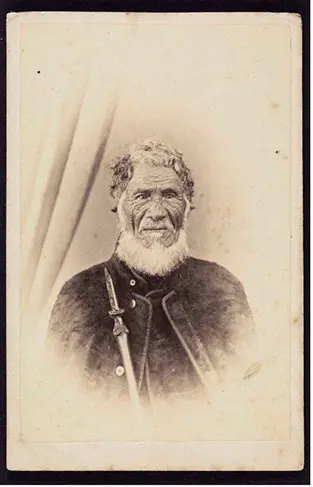 Black and white portrait photo of Eruera Maihi Patuone holding a taiaha (long wooden weapon).