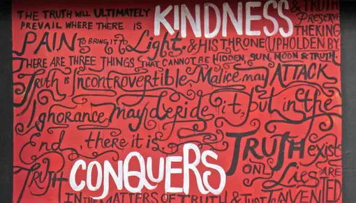 'Kindness conquers all' red, black and white wall mural.