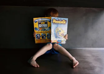 A young boy reading a comic.