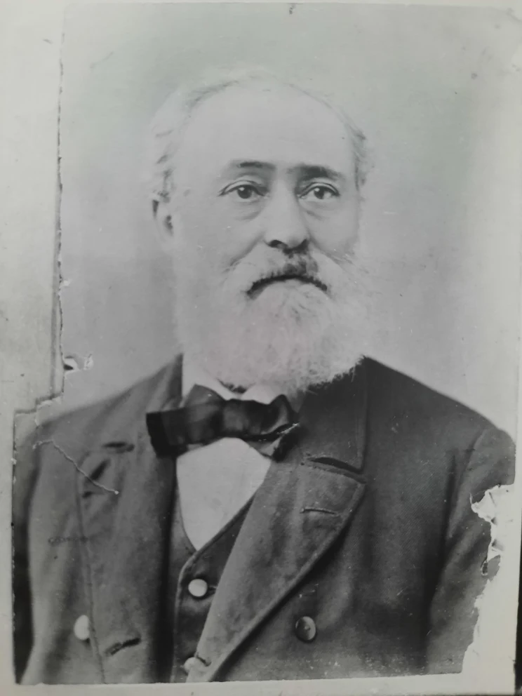 A black and white portrait of a older man with white beard and wearing formal dress.