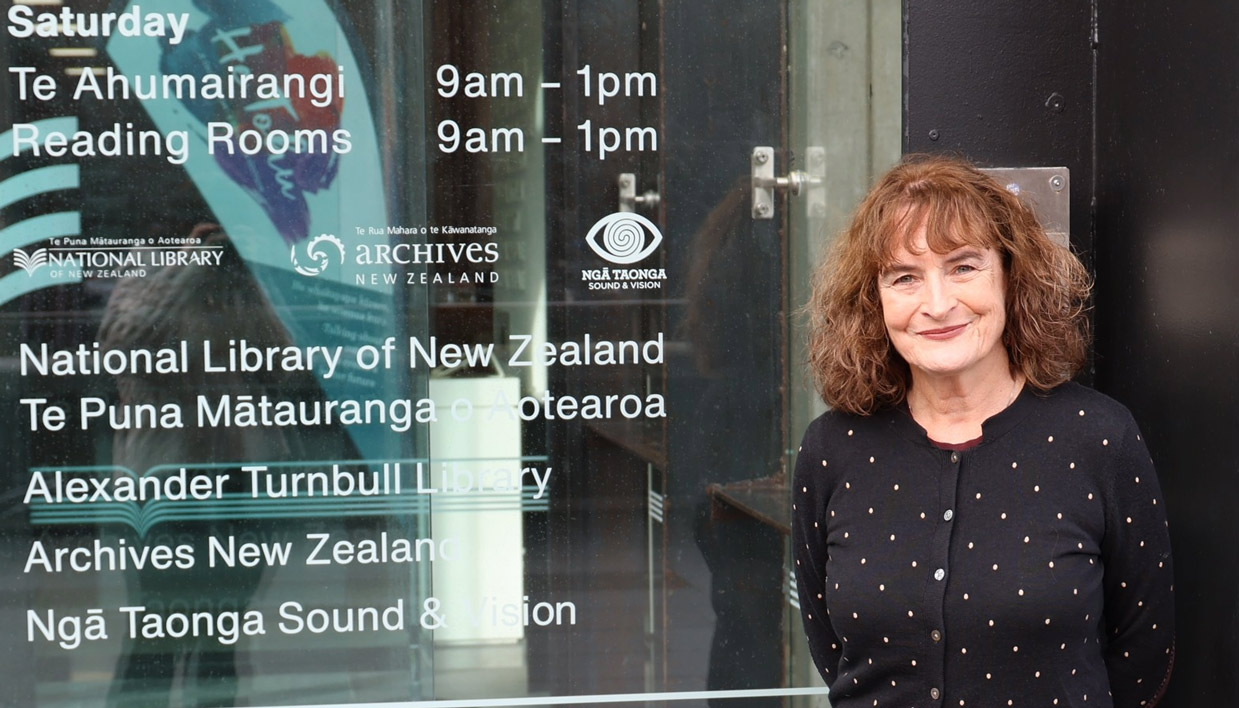 Kate De Goldi standing outside the front door of the National Library in Wellington.