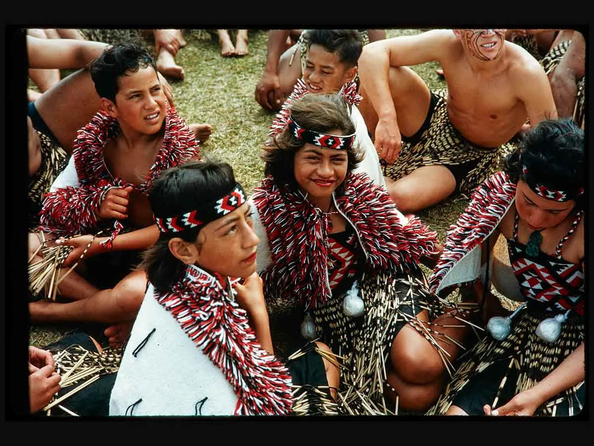 A group of young kapa haka performers. Some are wearing cloaks and tīpare (headbands).